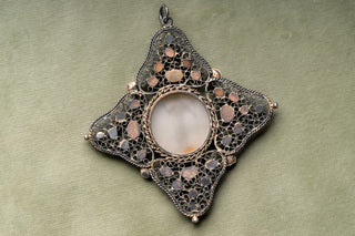 Reverse of the filigree pendant showing closed-back settings
